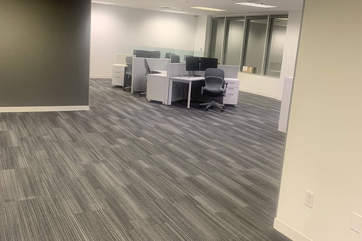 Office with cubicles and gray commercial flooring.