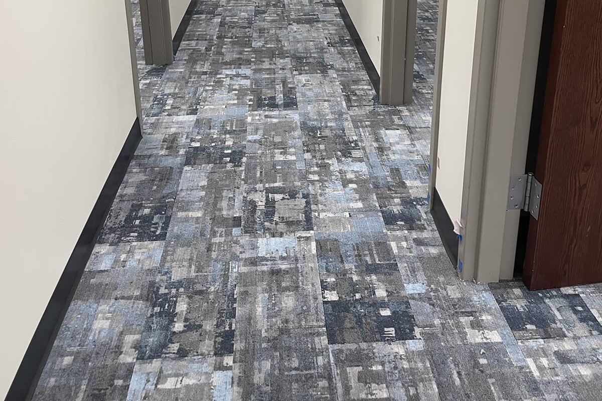 Blue and brown patterned carpet in an office hallway.